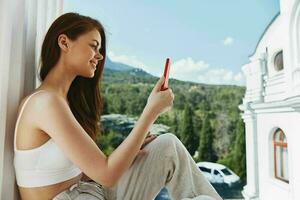 ritratto di bellissima donna con lungo capelli su un Aperto balcone verde natura estate giorno montagna Visualizza foto