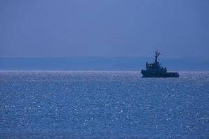 paesaggio un' piccolo nave andare in barca su il blu mare e senza nuvole cielo foto