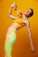 donna con floreale hawaiano ghirlanda in giro sua collo ha divertimento danza e sorridente nel luminosa Abiti su arancia sfondo con occhiali da sole, stile di vita festa nel hawaiano stile foto