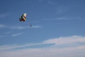 colorato paracadute tirato di barca su il spiaggia foto
