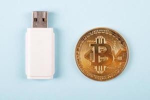 moneta d'oro bitcoin criptovaluta con il primo piano chiavetta USB foto