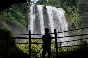 silhouette uomo su il grotta nel davanti di grande acqua autunno, semarang centrale Giava. il foto è adatto per uso per avventura soddisfare media, natura manifesto e foresta sfondo.