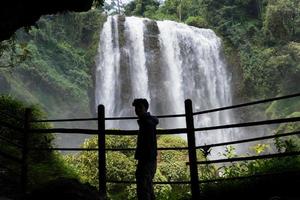 silhouette uomo su il grotta nel davanti di grande acqua autunno, semarang centrale Giava. il foto è adatto per uso per avventura soddisfare media, natura manifesto e foresta sfondo.