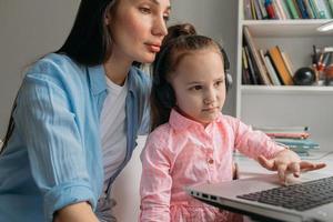 genitore che aiuta il bambino con l'e-learning foto