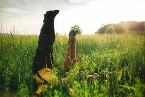 ragazzo con ragazza in un campo sdraiato sull'erba verde con le gambe e le mani in alto. foto