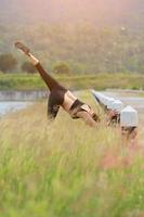 giovane ragazza fare yoga fitness esercizio mattina Alba all'aperto nel il prato bellissimo montagne paesaggio. meditazione e relax. foto