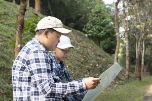 asiatico ragazzi utilizzando binocolo per fare il osservazione uccelli nel tropicale foresta durante estate campo, idea per apprendimento creature, natura animali e insetti al di fuori il aula. foto