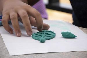 un autistico ragazzo modanatura diverso forme di colorato plastilina preparato di genitori a casa nel ordine per sviluppare vario aspetti nel loro figlio quale ha Più lentamente cervello sviluppo di normale bambini. foto