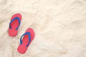 mare su il spiaggia orma persone su il sabbia e pantofola di piedi nel sandali scarpe su spiaggia sabbie sfondo. viaggio vacanze concetto. foto