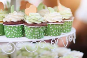 nozze cioccolato cupcakes nel verde tazza con ghirlanda luci bokeh e luce del sole sfondo foto