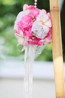 artificiale rosa fiori sospeso e argilla Bambola decorazione su albero nel matrimonio. nozze decorativo nel il verde giardino all'aperto. foto