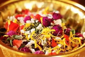 rosso rosa e calendula fiori petali nel oro vassoio nel tradizione tailandese nozze cerimonia e buddismo nel il tempio foto