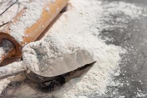 morbido messa a fuoco avvicinamento, Farina orecchie di Grano orzo cucinando, pane, e biscotti disposte su un' di legno tavolo superficie nel un' rustico cucina, superiore Visualizza. foto