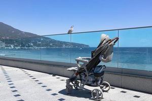 un vuoto bambino passeggino sta su il lungomare di il mare. foto