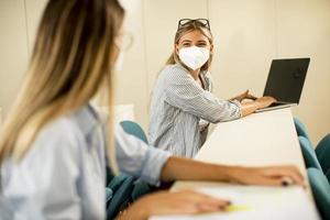 studentessa che indossa una maschera medica protettiva per il viso per la protezione da virus in aula foto