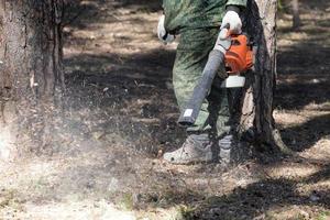 un' uomo usi un' palmare ventilatore nel il parco. foto