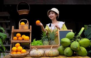 Asia donna vendita un' naturale varietà di frutta a il azienda agricola restare foto