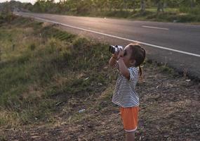 carino ragazza guardare attraverso binocolo, concetto di escursionismo, campeggio e avventura. foto