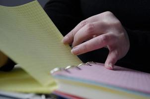 un' persona lettura libri vicino il finestra. mani giri al di sopra di libro pagina. foto