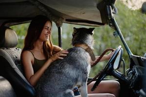donna e sua rauco cane felicemente in viaggio nel auto Sorridi con denti autunno camminare con animale domestico, viaggio con cane amico foto