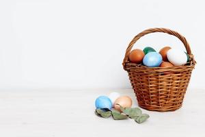 Pasqua vacanza con colorato uova nel un' cestino leggero sfondo primavera i regali foto