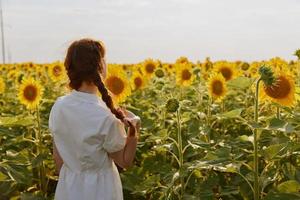 donna di indietro guardare nel il girasole campo paesaggio foto