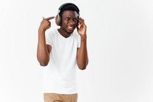 uomo di africano aspetto con cuffie ascoltando per musica tecnologia foto