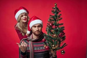giovane sposato coppia Natale albero giocattoli vacanza gioia rosso sfondo foto