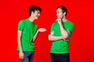 Due uomini nel verde magliette siamo in piedi lato di lato comunicazione foto