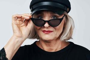 anziano donna nel alla moda Abiti nero cappello studio in posa foto