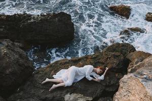 bellissimo sposa nel bianca nozze vestito su mare riva bagnato capelli inalterato foto