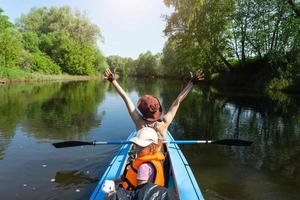 famiglia kayak viaggio. mamma e figlia canottaggio un' barca su il fiume, un' acqua escursione, un' estate avventura. eco-friendly e estremo turismo, attivo e salutare stile di vita foto