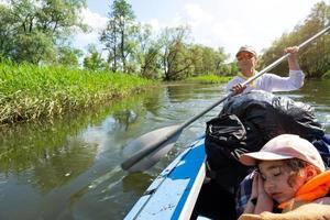 gita in kayak in famiglia. padre e figlia in barca a remi sul fiume, un'escursione in acqua, un'avventura estiva. turismo eco-friendly ed estremo, stile di vita attivo e sano foto