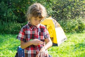 ragazza spruzza spray antizanzare sulla pelle in natura che le morde mani e piedi. protezione dalle punture di insetti, repellente sicuro per i bambini. attività ricreative all'aperto, contro le allergie. estate foto