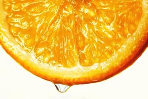 arancia fetta con un' far cadere di acqua vicino su su un' bianca sfondo foto