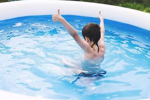 ragazzo nuotate nel il piscina. bambino nel il piscina all'aperto foto