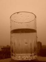 bicchiere di chiaro freddo acqua è metà pieno foto
