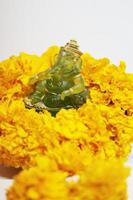 Smeraldo verde Ganesha statua Dio è il signore di successo Dio di induismo su calendula fiori isolato su bianca sfondo. foto