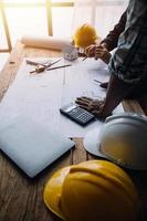 costruzione e struttura concetto di ingegnere o architetto incontro per progetto Lavorando con compagno e ingegneria utensili su modello edificio e planimetria nel Lavorando luogo, contrarre per tutti e due aziende. foto