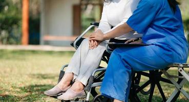 asiatico femmina mani toccante vecchio femmina mano porzione mani prendere cura di il anziano concetto nel parco ospedale foto