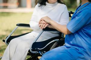 asiatico femmina mani toccante vecchio femmina mano porzione mani prendere cura di il anziano concetto nel parco ospedale foto