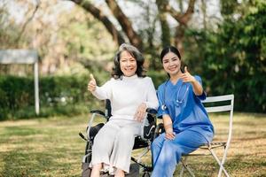 asiatico femmina mani toccante vecchio femmina mano porzione mani prendere cura di il anziano concetto nel parco ospedale foto