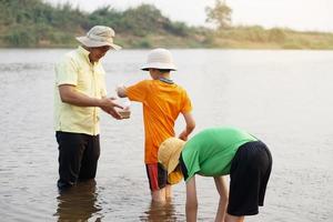 asiatico uomo insegnante e studenti siamo esplorando acqua a partire dal natura fonte. concetto, ecologia e ambiente studia. all'aperto estate campo attività. formazione scolastica. apprendimento di facendo. vita Esperienza. foto