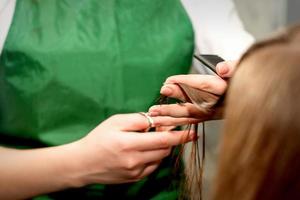 avvicinamento di un' parrucchiere taglio capelli suggerimenti di un' femmina cliente nel un' bellezza salone. foto