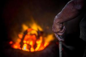 pericoloso lavoratore mani. un' Locale acciaio macchina parti fabbricazione cortile lavoratore fusione rottame su caldo forno. foto