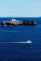 Visualizza a partire dal il magdalena penisola, santander, Spagna, con un' piccolo barca andare in barca e il moro isola nel il sfondo con suo 19 secolo faro foto