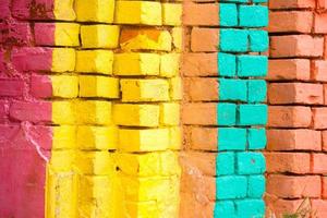 rosso, arancia, giallo e blu colore combinazione vecchio strutturato danno parete con colorato mattoni. foto