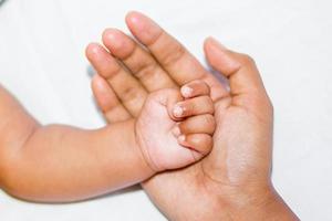 un' nuovo Nato del bambino morbido mano su La madre di mano su un' bianca sfondo. foto