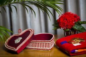 fatto a mano fibra ornamenti scatola con tradizionale gioielleria su il di legno tavolo. indiano tradizionale gioielleria e bridal saree. foto