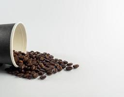 arrostito arabica caffè fagioli, pronto per rendere caffè quello persone piace per bere. posto nel un' nero caffè tazza carta su il sfondo. sembra bellissimo e appetitoso. bere. foto